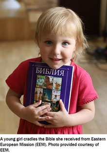 Girl Cradles the Bible Eastern European Mission