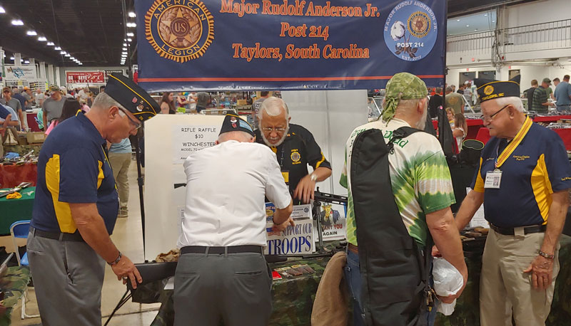 Members of American Legion Major Rudolf Anderson, Jr. Post 214 greet visitors to the August Gun Show. They were informing other veterans know how the American Legion can help them in their civilian life and about the camaraderie of the Legion. Pictured: 2nd Vice Commander John Banning, back to camera Commander Jack Dorn. In blue shirt Museum Director Peter Butchart.