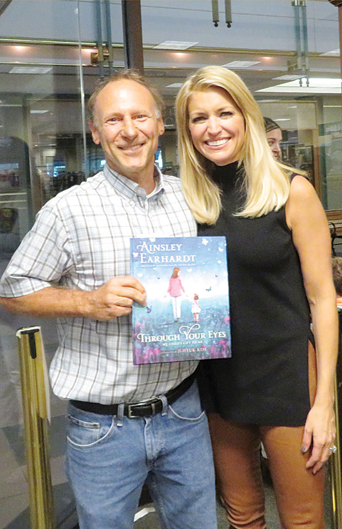 Jeff West, with Ainsley Earhardt, holding her book “Through Your Eyes: My Child’s Gift to Me.”